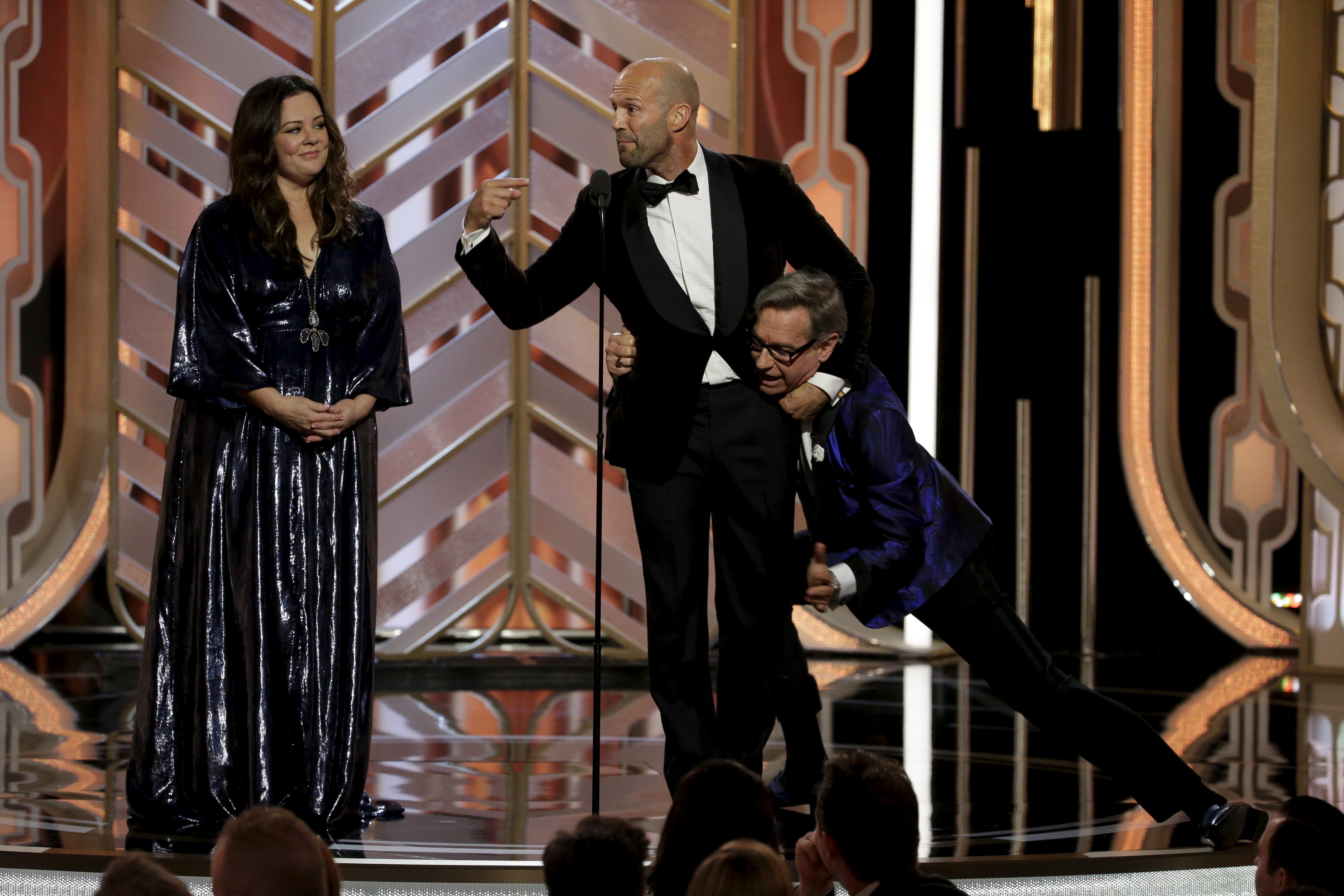 Melissa McCarthy (L) Jason Statham (C) and Paul Feig on stage at the 73rd Golden Globe Awards in Beverly Hills, California January 10, 2016. REUTERS/Paul Drinkwater/NBC Universal/Handout For editorial use only. Additional clearance required for commercial or promotional use. Contact your local office for assistance. Any commercial or promotional use of NBCUniversal content requires NBCUniversal's prior written consent. No book publishing without prior approval. - RTX21S66